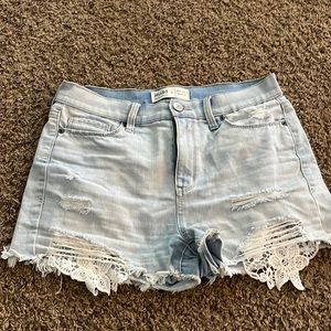 light blue jean shorts with flower pattern at bottom
